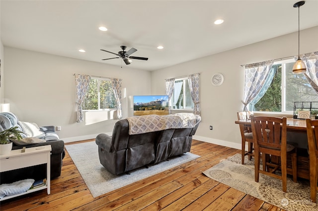 living room with light hardwood / wood-style flooring, ceiling fan, and plenty of natural light