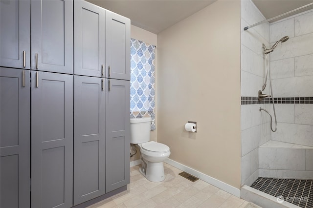 bathroom with toilet and a tile shower