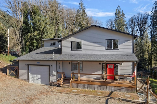 view of property with a garage and covered porch