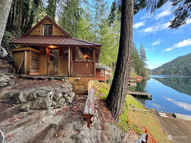 view of front of house with a water view and a dock