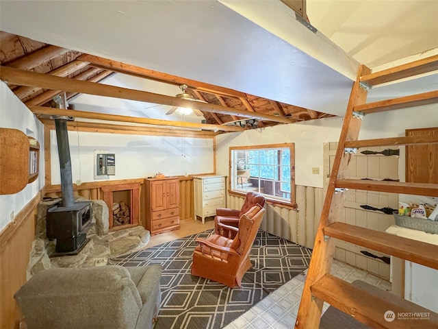 basement with a wood stove and ceiling fan