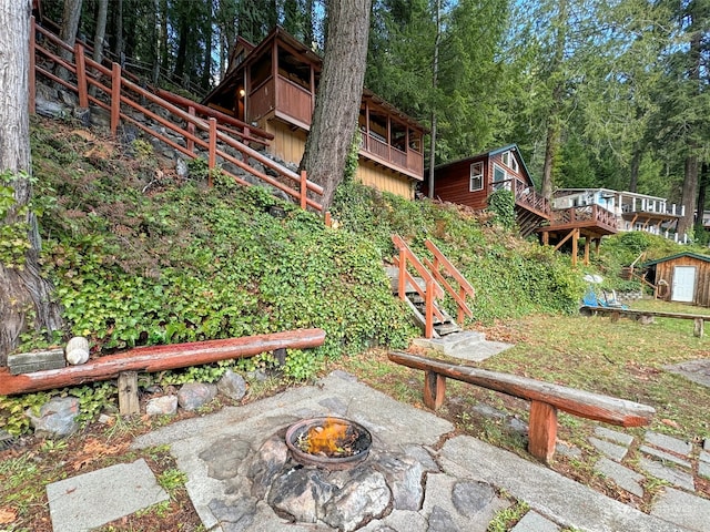 view of yard featuring a shed and a fire pit