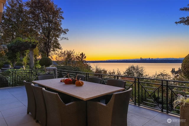 patio terrace at dusk with a balcony and a water view