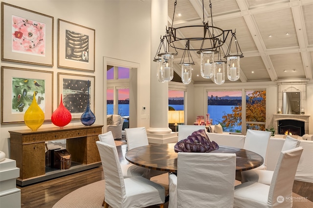 dining space with coffered ceiling, a water view, dark hardwood / wood-style floors, a towering ceiling, and beamed ceiling