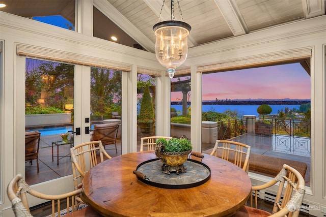 sunroom with french doors, vaulted ceiling with beams, a water view, and an inviting chandelier