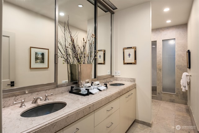 bathroom with a tile shower, tile patterned floors, and vanity