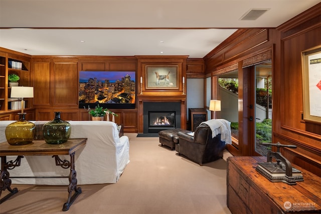 living room featuring wooden walls and light colored carpet