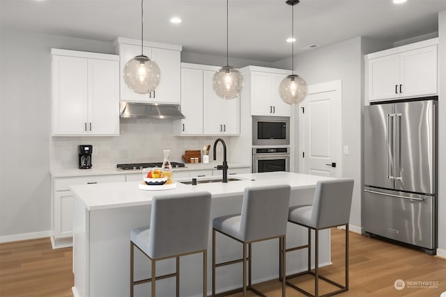 kitchen featuring a center island with sink, light hardwood / wood-style floors, white cabinets, and stainless steel appliances