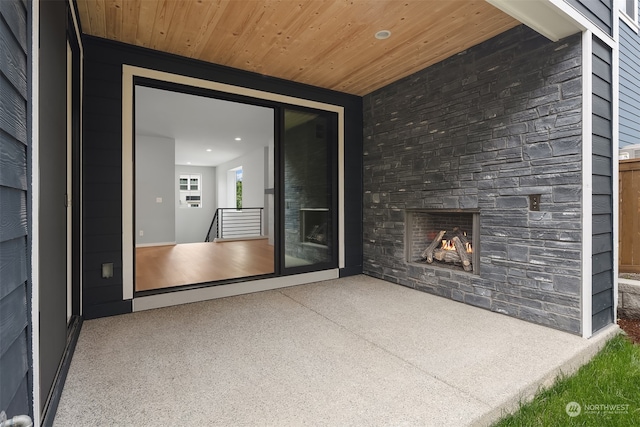 interior space with a stone fireplace and a patio