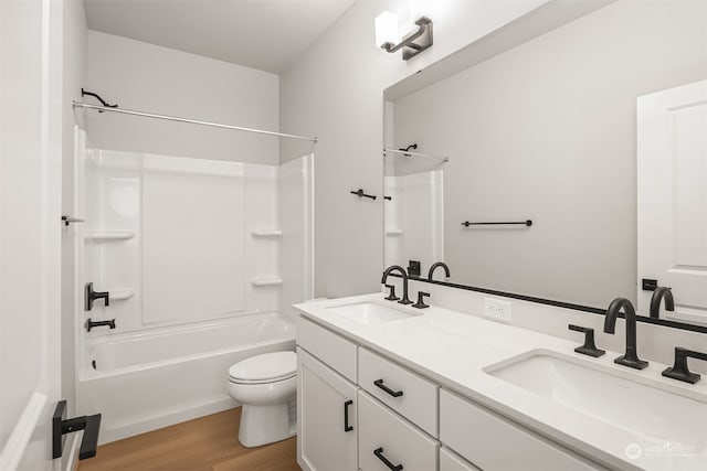 full bathroom with hardwood / wood-style floors, vanity, shower / bathtub combination, and toilet