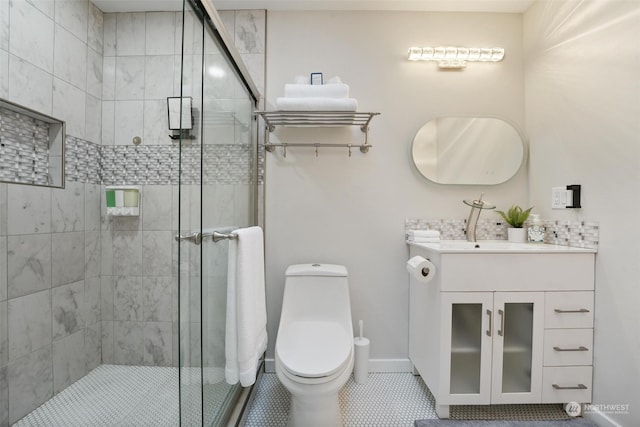 bathroom with tile patterned flooring, vanity, a shower with shower door, and toilet