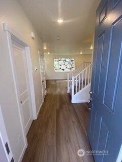 hallway with baseboards and wood finished floors