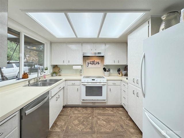 kitchen with white appliances, white cabinetry, dark parquet floors, and sink