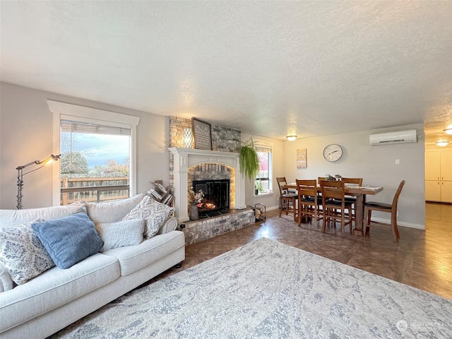 living room with a wall mounted air conditioner, a fireplace, and a textured ceiling