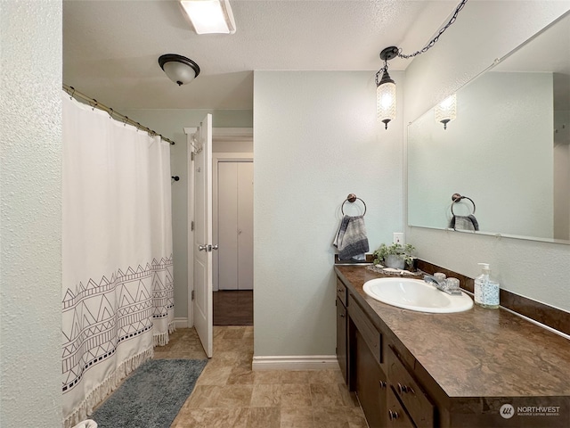 bathroom featuring a textured ceiling and vanity