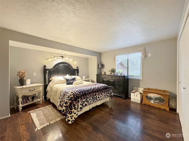 bedroom with a textured ceiling and dark wood-type flooring