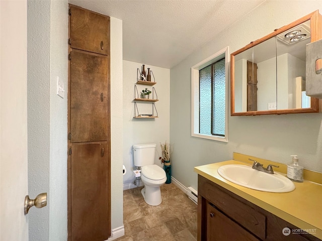 bathroom featuring baseboard heating, vanity, a textured ceiling, and toilet