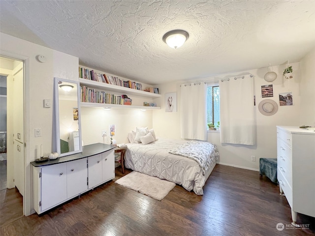 bedroom featuring a textured ceiling and dark hardwood / wood-style flooring