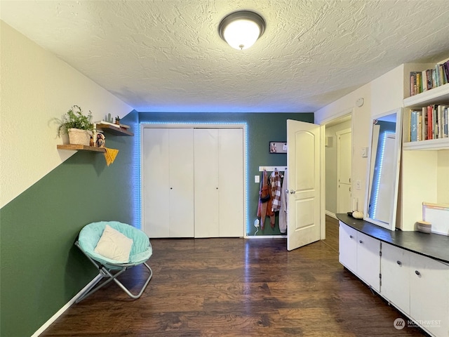 interior space featuring a textured ceiling and dark hardwood / wood-style floors