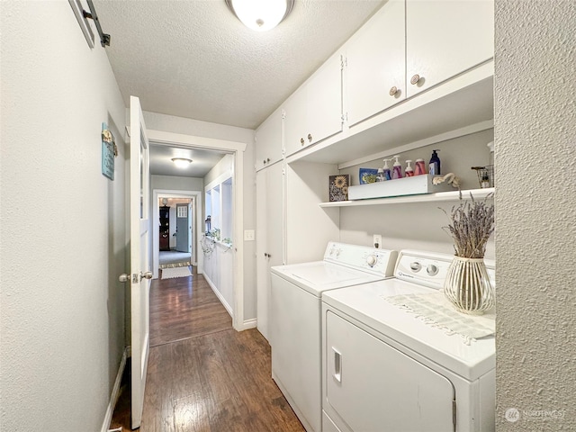 laundry room with dark hardwood / wood-style floors, cabinets, a textured ceiling, and washing machine and clothes dryer