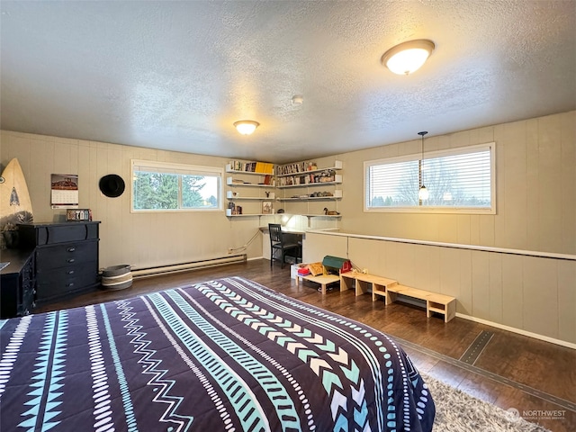 bedroom featuring dark hardwood / wood-style flooring, a baseboard radiator, and a textured ceiling