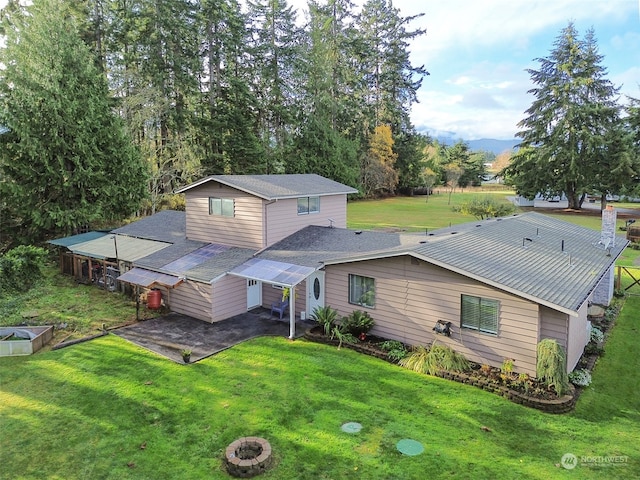 back of property with a lawn and a patio area