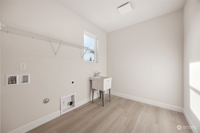 laundry room featuring electric dryer hookup, hookup for a washing machine, light hardwood / wood-style flooring, and gas dryer hookup