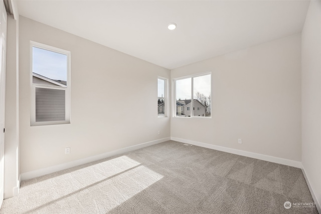 spare room with light carpet and plenty of natural light