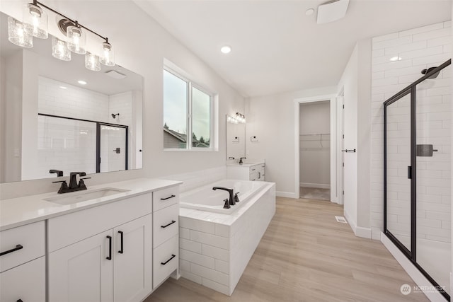 bathroom with vanity, hardwood / wood-style floors, and separate shower and tub