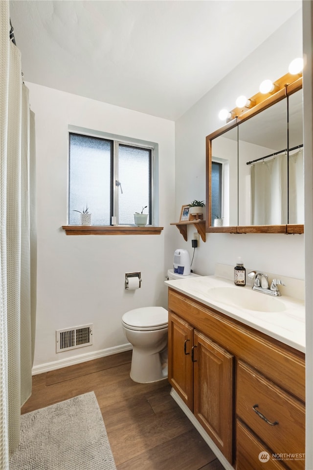 bathroom with hardwood / wood-style flooring, vanity, and toilet