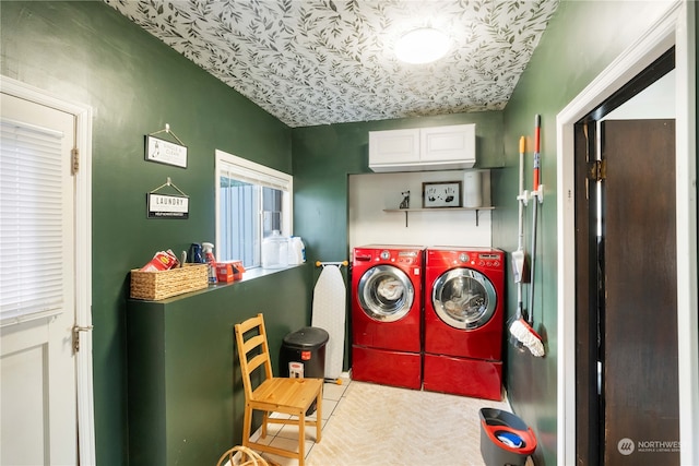 clothes washing area featuring light tile patterned flooring, cabinets, and washing machine and clothes dryer