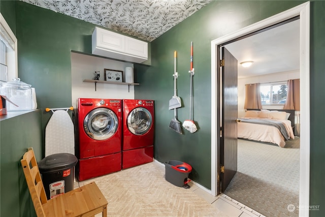 laundry area with light colored carpet, cabinets, and separate washer and dryer