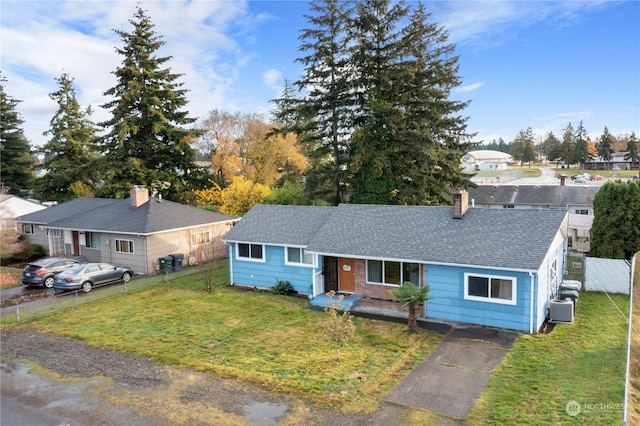 ranch-style house with a front yard and cooling unit