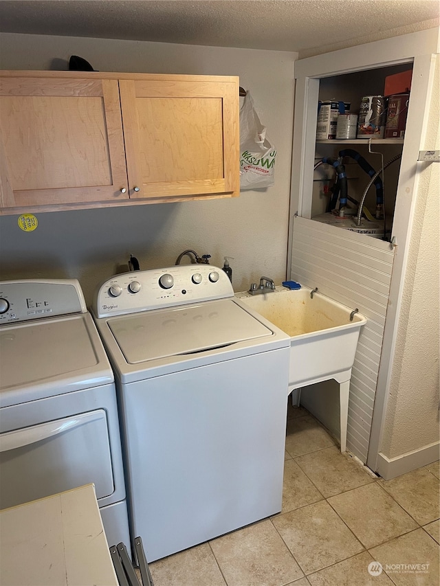 laundry area with separate washer and dryer, light tile patterned floors, cabinets, and a textured ceiling