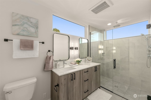 bathroom with tile patterned floors, toilet, vanity, and walk in shower