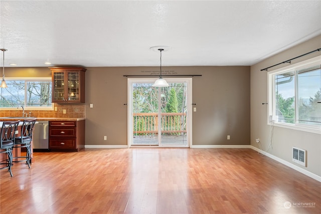 dining room with sink, plenty of natural light, and light wood-type flooring