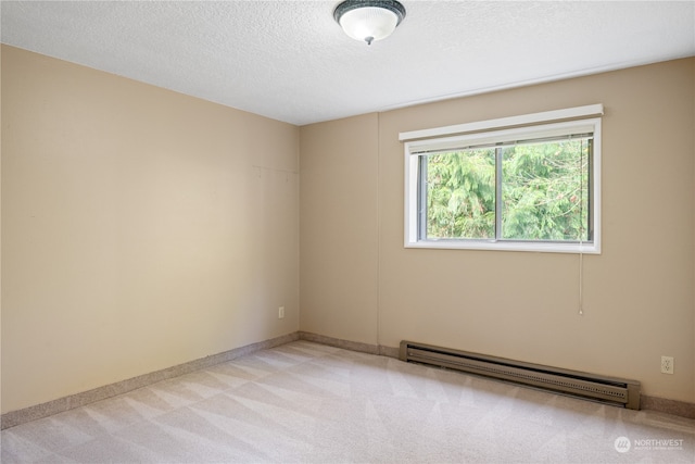 carpeted spare room featuring a textured ceiling and a baseboard heating unit