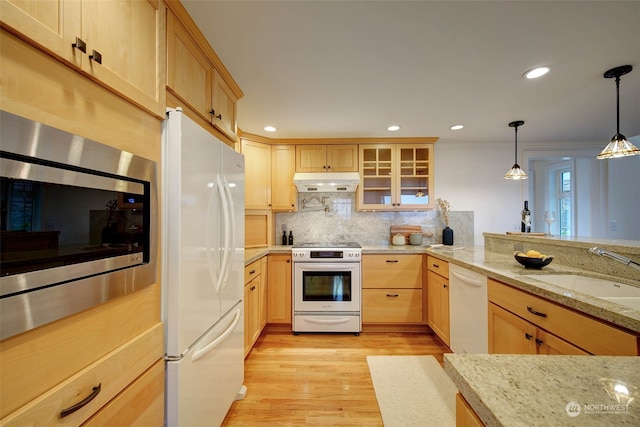 kitchen with pendant lighting, light brown cabinets, white appliances, sink, and light hardwood / wood-style floors