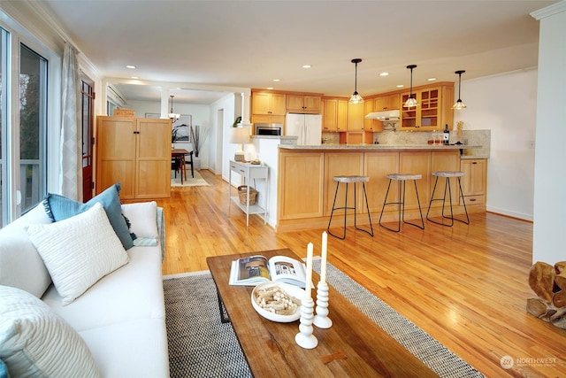 living room featuring light wood-type flooring and ornamental molding