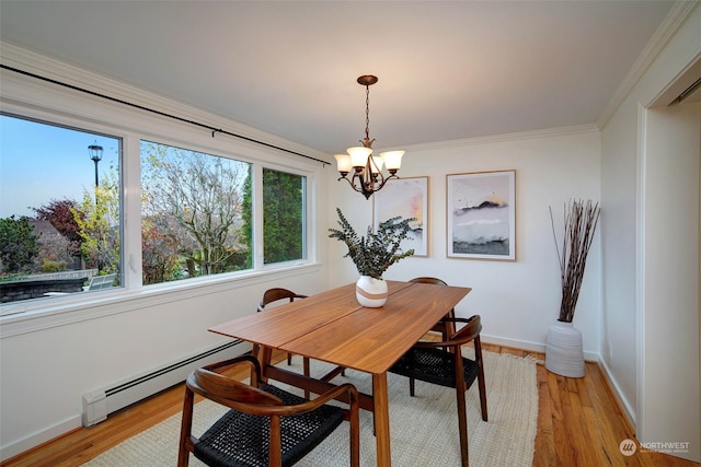 dining space with a notable chandelier, light hardwood / wood-style floors, crown molding, and a baseboard heating unit