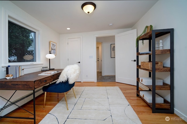 home office with baseboard heating and light hardwood / wood-style flooring