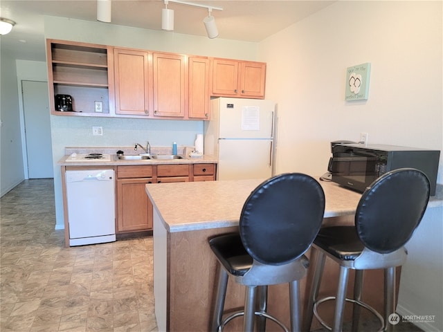 kitchen with a kitchen breakfast bar, white appliances, light brown cabinets, and sink