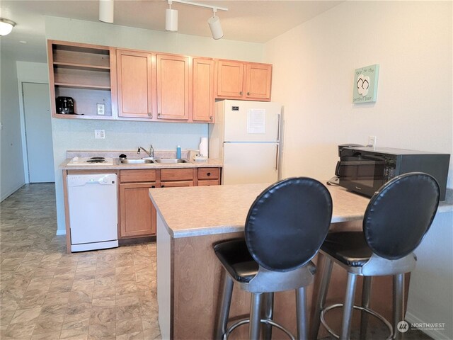 304 14th St NW Unit 103, Long Beach, WA 98631 - kitchen featuring white appliances, a sink, light countertops, a kitchen breakfast bar, and open shelves