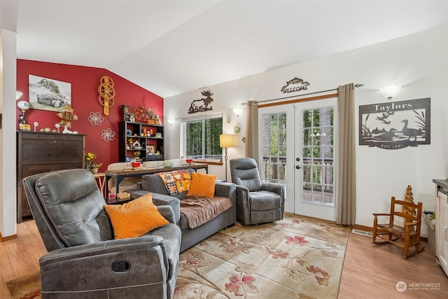 living room featuring french doors, light hardwood / wood-style floors, and vaulted ceiling