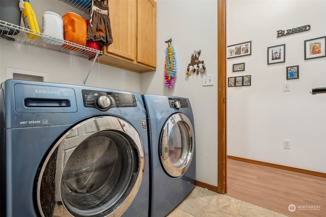 laundry area featuring cabinets, independent washer and dryer, and light hardwood / wood-style flooring