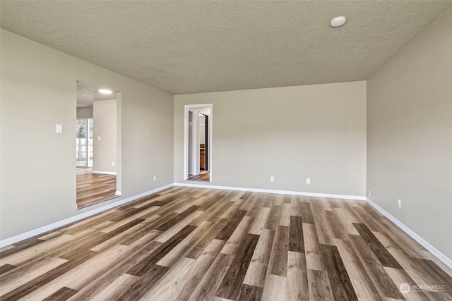 spare room with hardwood / wood-style floors and a textured ceiling