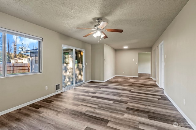 empty room with hardwood / wood-style flooring, ceiling fan, and a textured ceiling