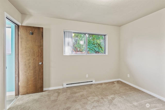 spare room with light carpet and a baseboard radiator