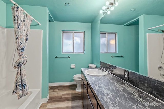 full bathroom with hardwood / wood-style floors, vanity, toilet, and shower / bath combo