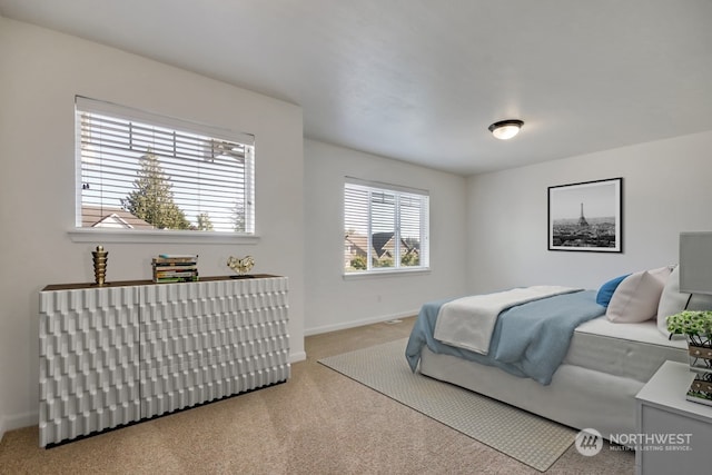 bedroom featuring baseboards and light colored carpet